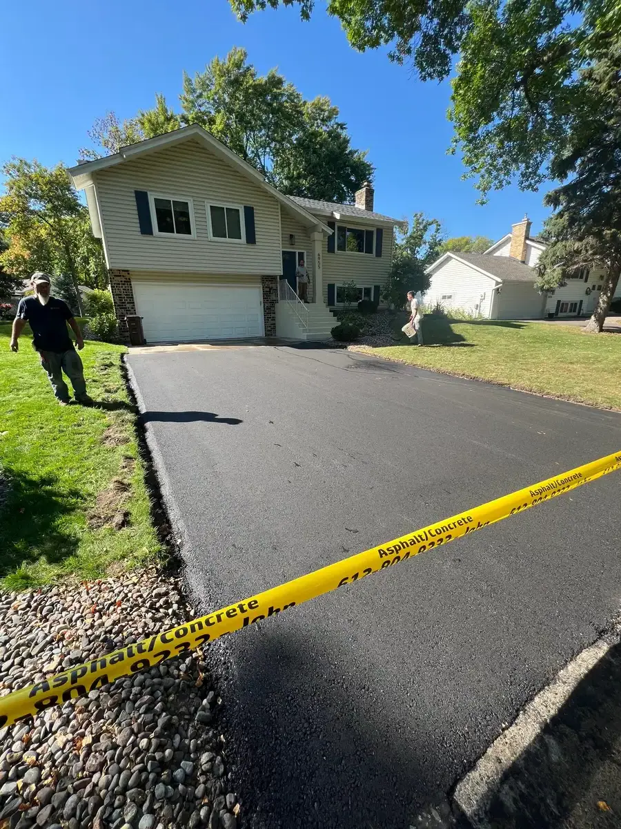 Asphalt driveway installation with crew on site
