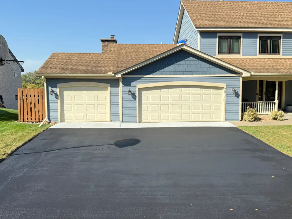 Wide asphalt driveway paving for two-car garage